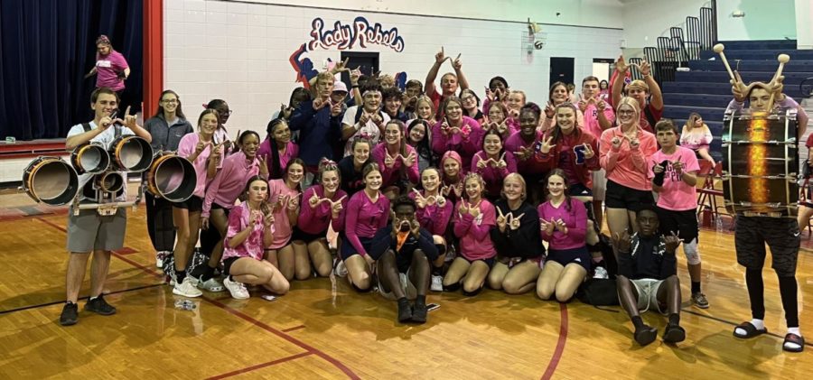 RA volleyball players and  their cheering section pose for a photo after the win against SCC. 