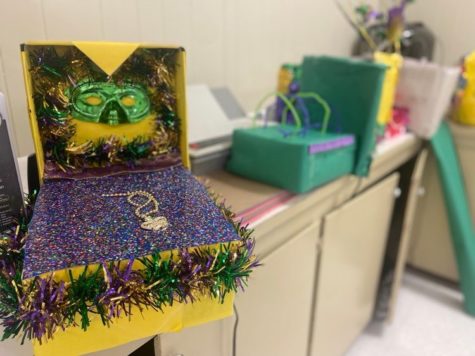 Sixth graders created Mardi Gras floats out of shoeboxes. 