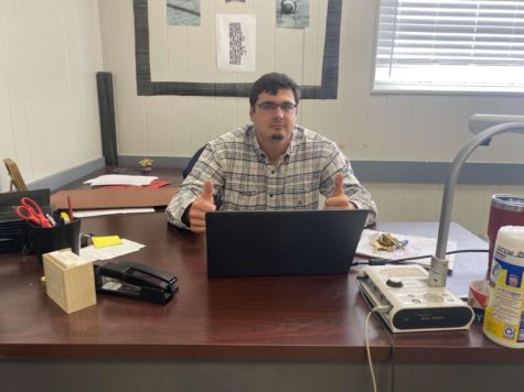 Coach Jordan Loving sits at his classroom desk. What does it say about his personality?