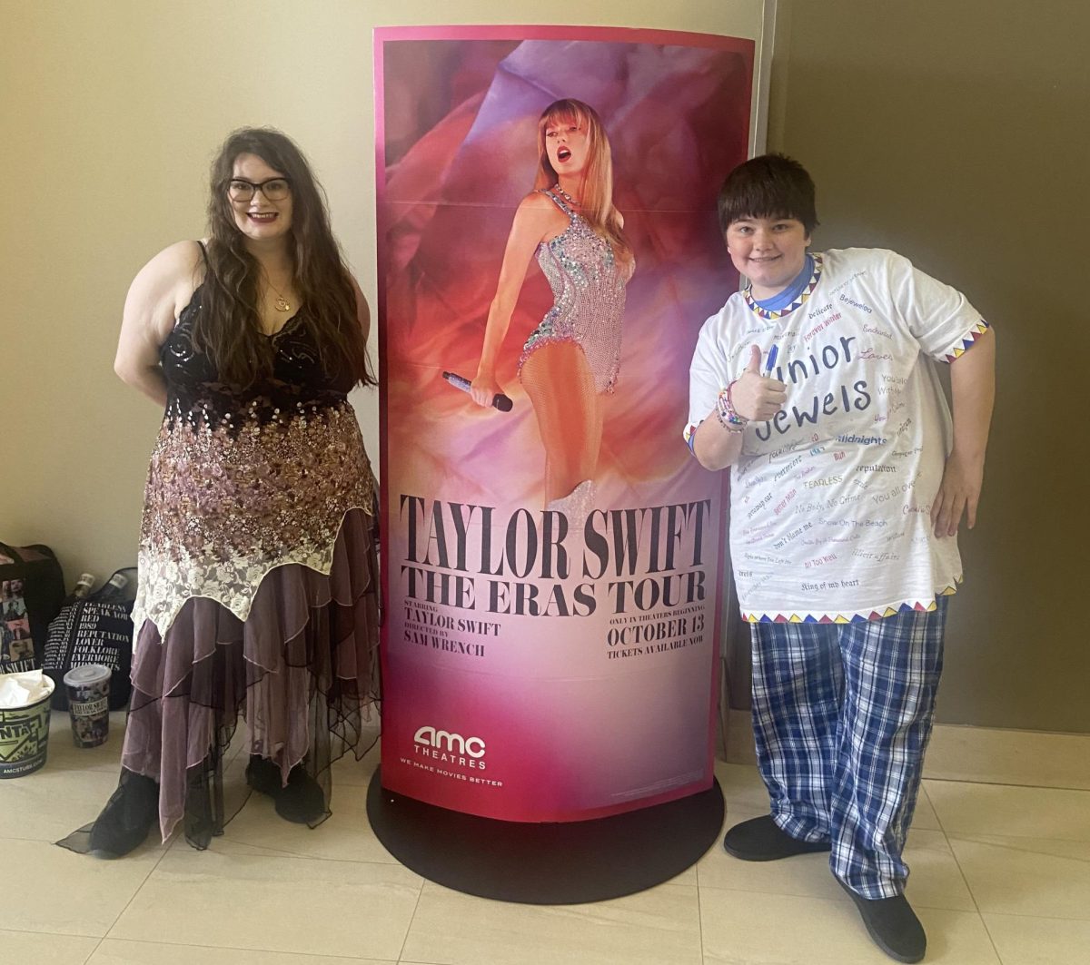 Author Jessie Weiler, left, and her brother Viktor pose next to the display for the Eras Tour Movie. 