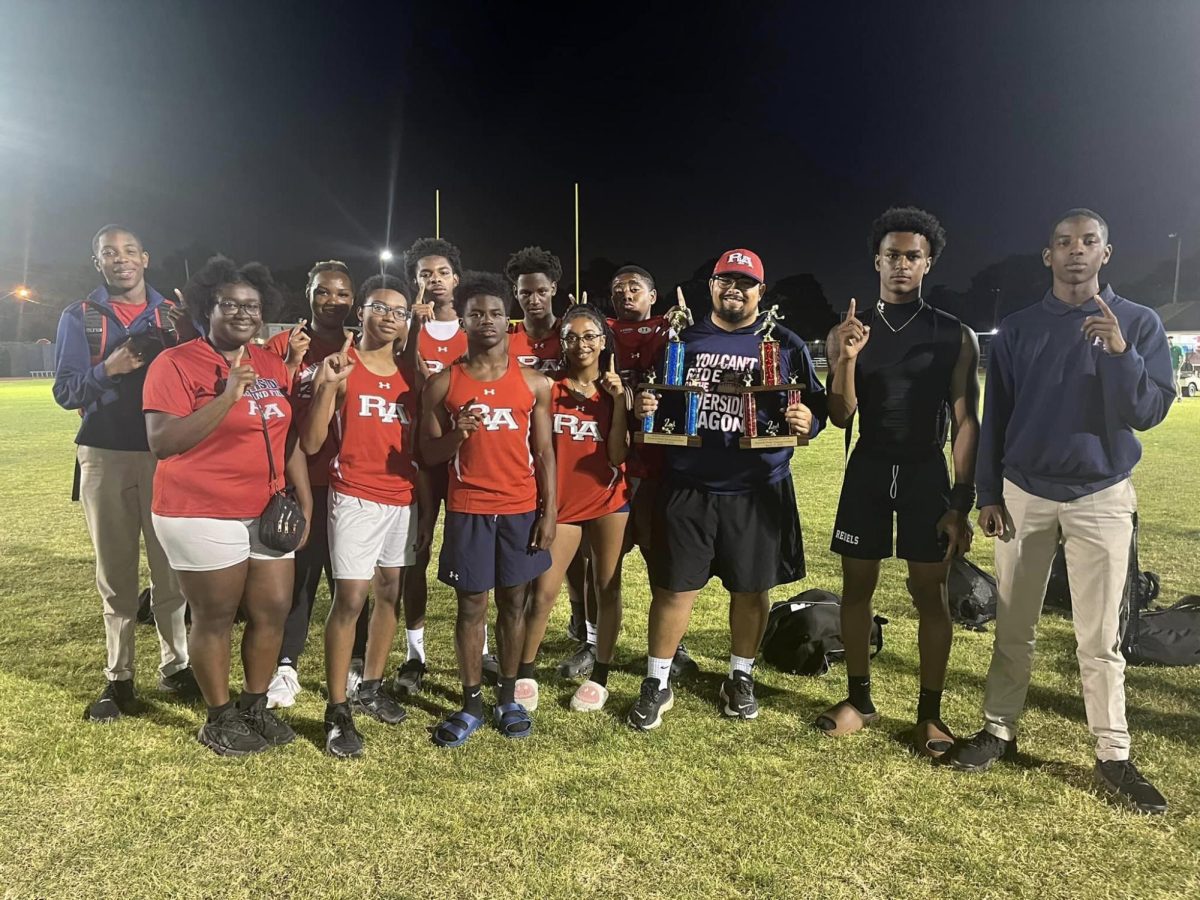 Riverside track coach Pierce Bonck celebrates with members of the boys and girls track teams after their strong showing at Wednesday nights District Meet. 